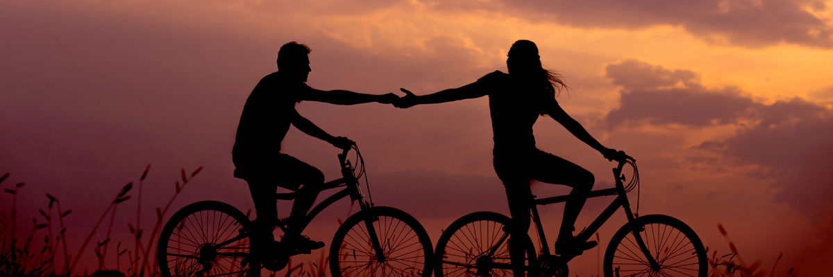 Couple riding bikes holding hands